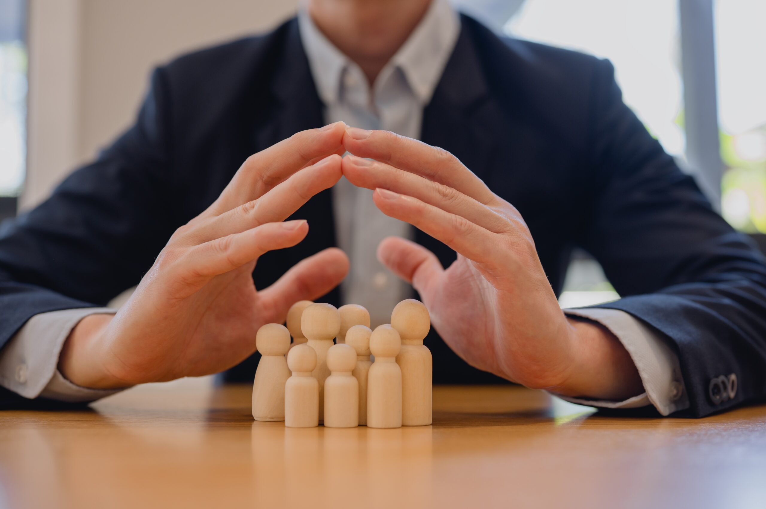 Businessman,Protecting,Wooden,People,Figures,By,Forming,A,Roof,With duty to defend
